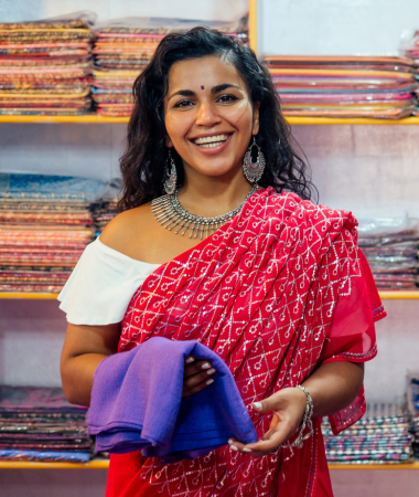 Happy woman entrepreneur holding handmade fabrics, showcasing success through digital empowerment and business expansion