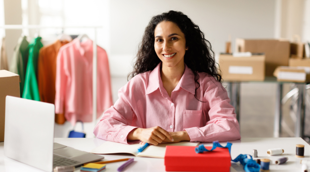 Smiling woman entrepreneur managing her online store and website, symbolizing business growth, trust-building, and self-reliance