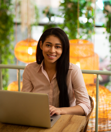Smiling team member working on a laptop, representing a dedicated digital marketing support team.