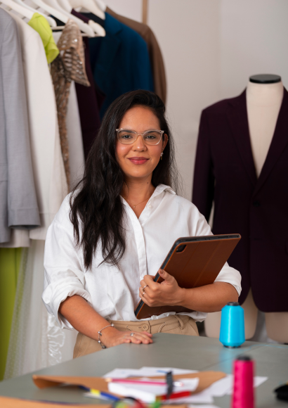 Woman entrepreneur setting up her digital business workspace using a tablet and essential tools.