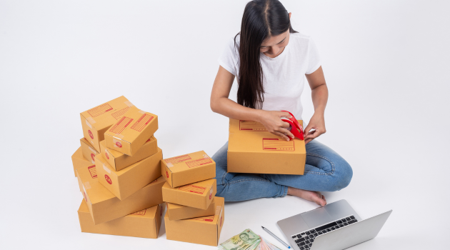 Woman packaging products for delivery, showcasing success through digital marketing and business growth.
