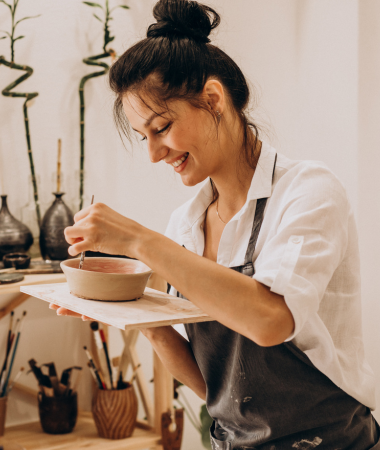 Smiling woman entrepreneur engaged in creative work, symbolizing innovation and digital empowerment.