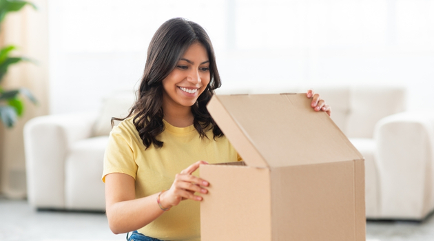 Woman preparing an e-commerce shipment, symbolizing success in online reselling and digital marketing.